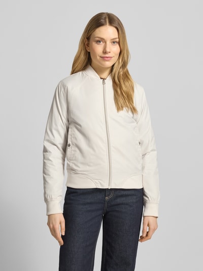 Frauenmodel trägt Regular Fit Jacke mit Stehkragen Modell 'Zaymi' von CARS JEANS in hellem Beige mit Eingrifftaschen, Reißverschluss, elastische Abschlüsse, Rückenlänge 61 cm, Schulterbreite 41 cm, Brustweite 39 cm, Ärmellänge 60 cm, Ganzkörperansicht von vorne.
