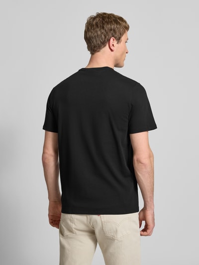 Männermodel trägt T-Shirt mit Rundhalsausschnitt und Logo von Calvin Klein Jeans in Schwarz, Reine Baumwolle, Regular-Fit, Rückenlänge 69 cm, Ganzkörperansicht Rückansicht.