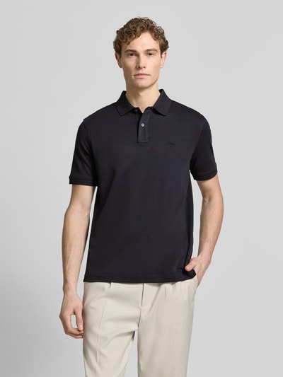 Männermodel trägt Regular Fit Poloshirt mit Logo-Stitching von Fynch-Hatton, reine Baumwolle in Dunkelblau, Ganzkörperansicht von vorne.