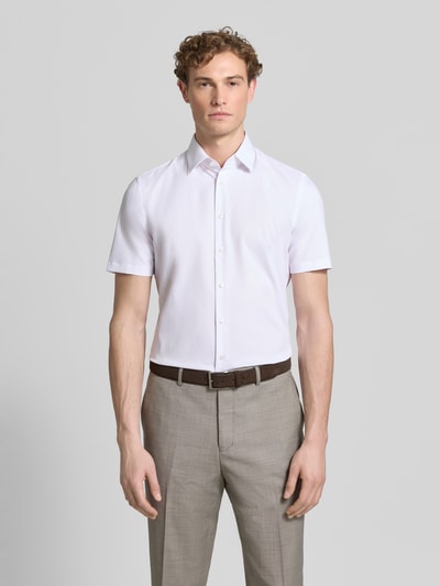Männermodel trägt Slim Fit Business-Hemd mit Kentkragen von Jake*s, Elastischer-Material-Mix, Knopfleiste, Kurzärmelig, Ganzkörperansicht von vorne.