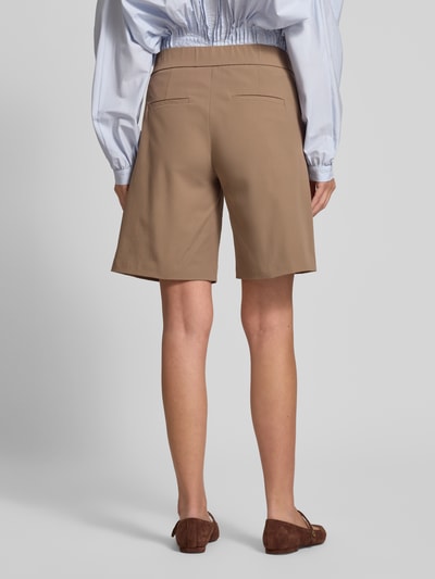 Frauenmodel trägt Schlupfbermuda Techno Cotton Superstretch von Raffaello Rossi, Regular-Fit, elastischer Bund, Gesäßtaschen, Modell ISKA, beige, glatte Textur, Ganzkörperansicht Rückansicht, Bundweite 39 cm, Innenbeinlänge 24 cm bei Größe 36.