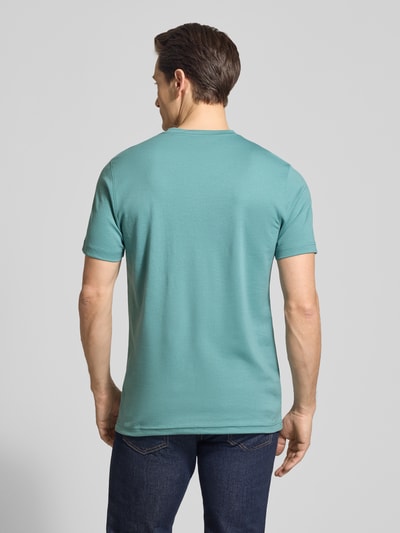 Männermodel trägt T-Shirt mit Rundhalsausschnitt und Brusttasche von Christian Berg Men, Material-Mix mit Baumwoll-Anteil, Regular-Fit, Rückenlänge 72 cm in Größe M, dezentes Türkis, glatte Textur, Ganzkörperansicht Rückansicht.