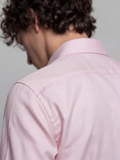 Männermodel trägt Regular Fit Businesshemd aus reiner Baumwolle Modell 'New Kent' von Seidensticker in zartem Rosa, Nahaufnahme Rückansicht. Herren Businesshemd von Seidensticker.