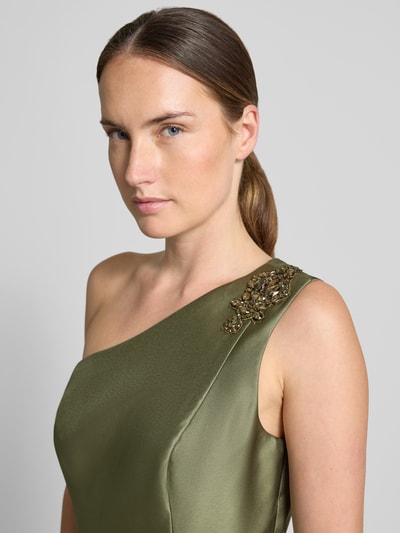 Frauenmodel trägt Midikleid mit Rüschenbesatz von Adrianna Papell, Satin in Olivgrün, Ziersteinbesatz, asymmetrisch, Nahaufnahme Oberkörper.