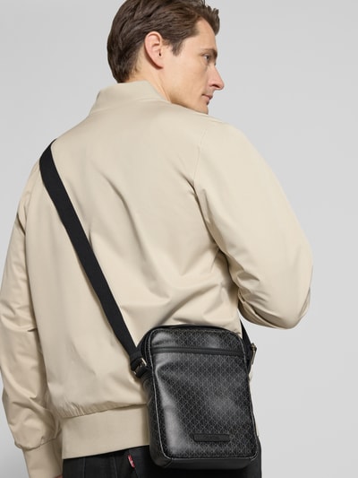 Mężczyzna model nosi Torebka mit Logo-Muster und Schulterriemen von CK Calvin Klein, kolor czarny, Naszywka z logo, Ganzkörperansicht Rückansicht