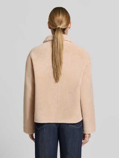 Frauenmodel trägt Regular Fit Jacke aus reiner Wolle von OAKWOOD in Beige mit Umlegekragen und aufgesetzten Taschen, Ganzkörperansicht Rückansicht.