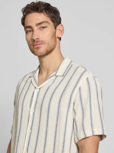 Męski model nosi Relaxed Fit Freizeithemd aus reiner Baumwolle Modell 'RLXCAL' von SELECTED HOMME, efekt: wzór na całej powierzchni, krój relaxed fit, kołnierzyk typu bowling, jednorzędowa listwa guzikowa, krótki rękaw, bawełna, zbliżenie na górną część ciała.