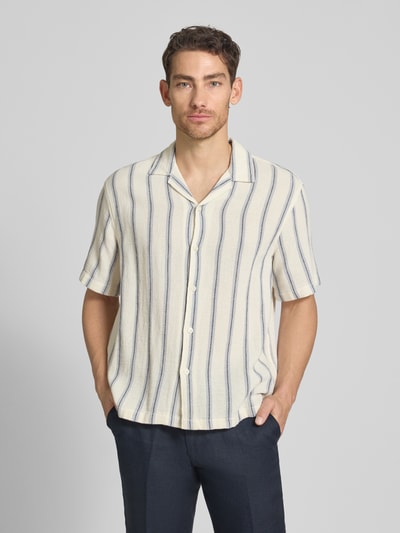 Męski model nosi Relaxed Fit Freizeithemd aus reiner Baumwolle Modell 'RLXCAL' von SELECTED HOMME, efekt: wzór na całej powierzchni, kołnierzyk typu bowling, listwa guzikowa jednorzędowa, krótki rękaw, materiał: bawełna, kolor kremowy i niebieski, tekstura miękka, całkowity widok z przodu.