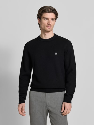 Männermodel trägt Regular Fit Pullover mit Schurwoll-Anteil Modell 'SETAL' von HUGO, Optik: Unifarben, Label-Patch, Nahaufnahme Oberkörper.