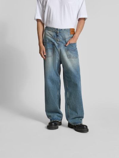 Männermodel trägt Loose Fit Jeans aus Baumwolle von VETEMENTS im Destroyed-Look mit 5-Pocket-Design, mittlere Waschung, Ganzkörperansicht von vorne.
