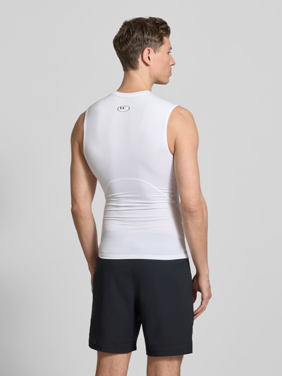 Męski model nosi Slim Fit Top mit Logo-Print von Under Armour, elastyczna mieszanka materiałów, okrągły dekolt, długość tyłu 65 cm, krój slim fit, widok całej sylwetki z tyłu.