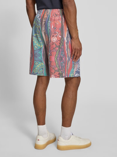 Männermodel trägt Straight Fit Shorts in Crochet-Optik mit Viskose-Anteil von COLUCCI, buntes Muster, elastischer Bund, Ganzkörperansicht Rückansicht.