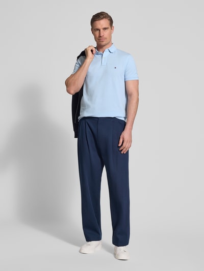 Männermodel trägt Regular Fit Poloshirt aus Baumwoll-Mix von Tommy Hilfiger, Optik: Unifarben, Logo-Stitching, Piqué, Ganzkörperansicht von vorne.