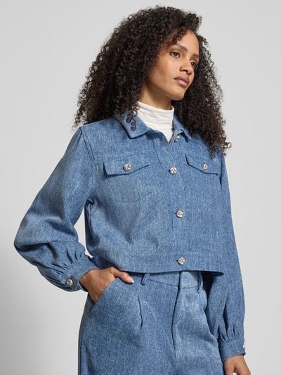 Frauenmodel trägt Blazer mit Knopfleiste Modell 'vally' von Gestuz in Blau, Regular-Fit, Hemdblusenkragen, Brusttaschen, Nahaufnahme Oberkörper. Rückenlänge 48 cm, Brustweite 42 cm, Ärmellänge 65 cm bei Größe 36.