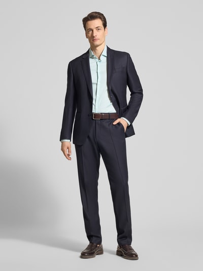 Männermodel trägt Slim Fit Freizeithemd aus Baumwoll-Mix von Tommy Hilfiger, jednolity kolor, melanż, krój slim fit, kołnierzyk typu kent, listwa guzikowa jednorzędowa, detal z logo, pas na plecach, zapięcie jednorzędowe, długi rękaw, mankiety kombi, zaokrąglone wykończenie, popelina, mieszanka bawełny, całkowity widok z przodu