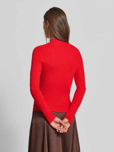Frauenmodel trägt Slim Fit Pullover mit Woll-Anteil von MYON in Rot, feine Strickstruktur, Stehkragen, Ganzkörperansicht Rückansicht.
