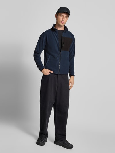 Männermodel trägt Fleecejacke mit Stehkragen von Blend, Regular-Fit, Reißverschluss, Eingrifftaschen, Brusttasche, Ganzkörperansicht von vorne.