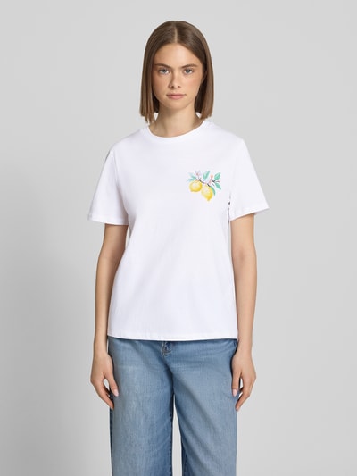 Frauenmodel trägt Regular Fit T-Shirt aus reiner Baumwolle Modell 'BRIANNA' von Pieces, weiß, Motiv-Print, Rundhals, kurzarm, glatte Jersey-Textur, Ganzkörperansicht von vorne.