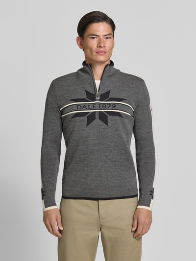 Männermodel trägt Wollpullover mit Label-Print Modell 'Nale' von Dale of Norway, reine Wolle, gerader Schnitt, Ganzkörperansicht von vorne.