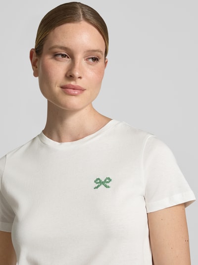 Frauenmodel trägt Damen T-Shirt mit floralem Stitching Modell 'Aminna' von ICHI in Weiß, Reine Baumwolle, Taillierte Passform, Nahaufnahme Oberkörper.