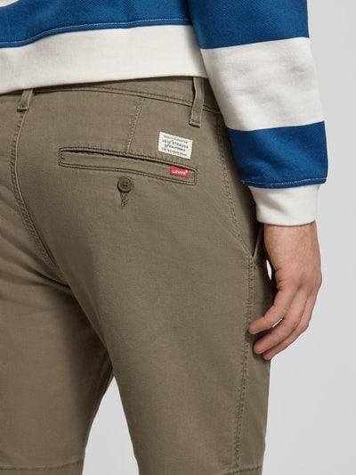 Männermodel trägt Chino Shorts aus Baumwoll-Mix mit Leinen-Anteil von Levi's®, beige Farbe, französische Taschen, Nahaufnahme Rückansicht.