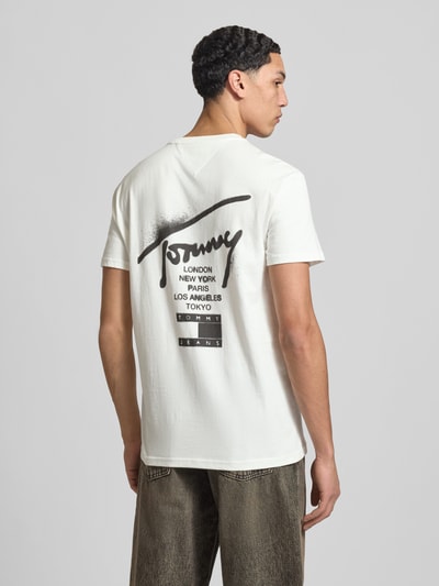 Männermodel trägt Regular Fit T-Shirt aus reiner Baumwolle von Tommy Jeans in Optik: Unifarben mit Label-Print, Ganzkörperansicht Rückansicht.