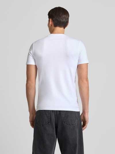 Männermodel draagt T-Shirt met Label-Detail van Guess in wit, regular fit katoen-elastaan mix, rechte zoom, geheel effen, rugaanzicht, Ganzkörperansicht Rückansicht.