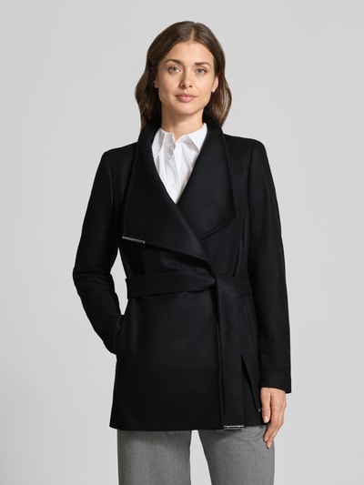 Frauenmodel trägt Kurzmantel aus Woll-Mix mit Bindegürtel Modell 'ROSESS' von Ted Baker in Schwarz, glatte Textur, Ganzkörperansicht von vorne. Damen Jacke mit Stehkragen, Label-Detail und Kaschmir-Anteil, Regular Fit.