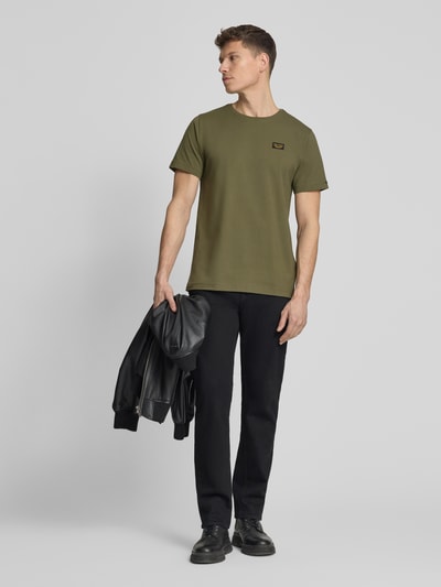 Männermodel trägt T-Shirt mit Label-Details und Rundhalsausschnitt von PME Legend aus Baumwoll-Elasthan-Mix, Regular-Fit, olive, Ganzkörperansicht von vorne. Rückenlänge bei Größe M: 70 cm.