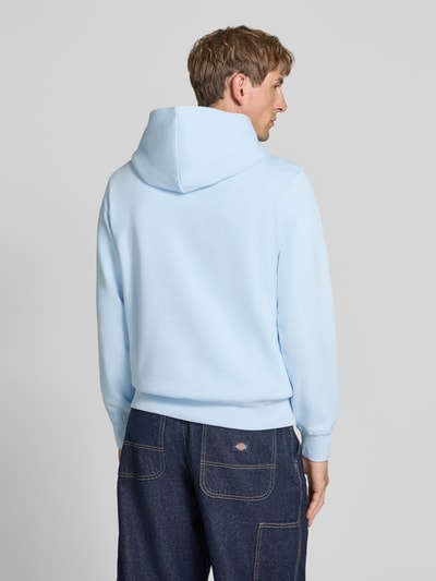 Männermodel trägt hellblauen Hoodie mit Label-Print Modell 'FREDERIKSBERG' von JACK & JONES aus Baumwoll-Mix, lockerer Schnitt, Ganzkörperansicht Rückansicht.