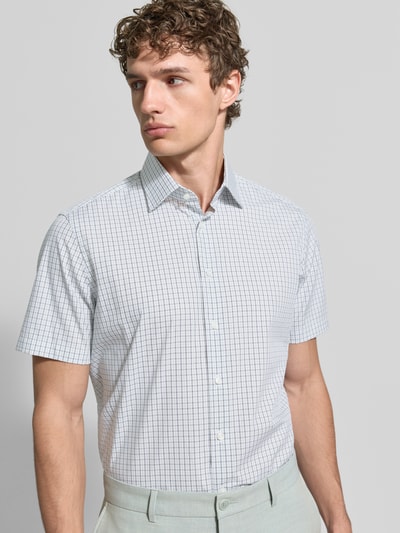 Männermodel trägt Regular Fit Business-Hemd aus Baumwolle mit Kentkragen von Christian Berg Men im Karo-Allover-Look, Nahaufnahme Oberkörper