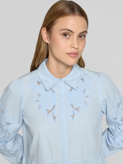 Frauenmodel trägt knielanges Hemdblusenkleid mit Lochstickerei Modell 'Zimia' von YAS aus Reine Baumwolle, Nahaufnahme Oberkörper.