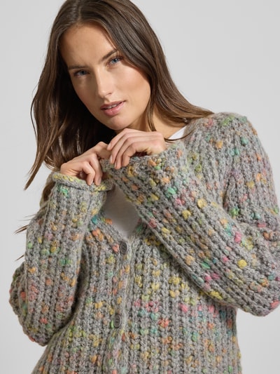Vrouwenmodel draagt Regular Fit Strickjacke mit Woll-Anteil van Smith and Soul, grofgebreid, V-hals, knoopsluiting, kleur grijs met kleurrijke stippen, materiaal-mix, close-up bovenlichaam.