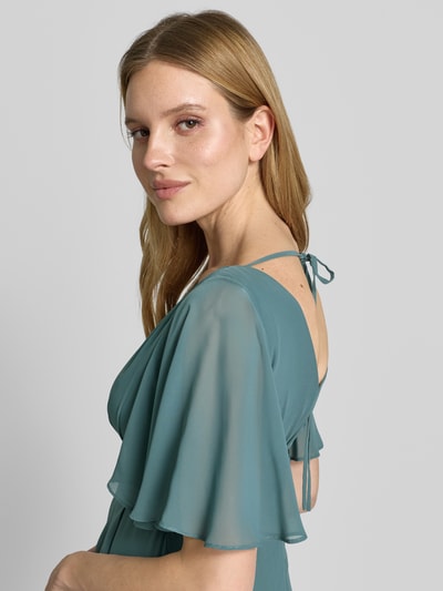 Modelka kobieca nosi Midikleid aus Chiffon mit tiefem V-Ausschnitt od Jake*s Cocktail, szyfon, taliowany fason, głęboki dekolt w serek, falbany, tasiemka w talii; długość tyłu w rozmiarze 36: 125 cm, szerokość w rozmiarze 36: 32 cm, długość rękawów w rozmiarze 36: 30 cm, detaliczne zdjęcie górnej części sylwetki z przodu.