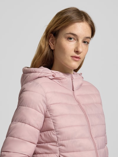 Modelka kobieca nosi Regular Fit Steppjacke mit Kapuze Modell 'TAHIA' od Only, pudrowy róż, pikowana tekstura, krój regular fit, zamek błyskawiczny, kaptur na troczki, boczne kieszenie, długi rękaw z elastycznymi mankietami, unikalna kolorystyka, widok z przodu, zbliżenie na górną część ciała.
