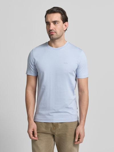 Männermodel trägt Regular Fit T-Shirt aus reiner Baumwolle Modell 'THOMPSON' von BOSS in Hellblau mit Label Print, Ganzkörperansicht von vorne.
