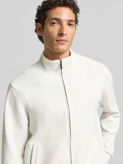 Männermodel trägt Sweatjacke mit Stehkragen und Zweiwege-Reißverschluss von Emporio Armani, heller Baumwoll-Mix, Nahaufnahme Oberkörper.