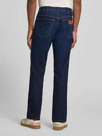 Männermodel trägt Straight Fit Jeans im 5-Pocket-Design Modell 'Texas' von Wrangler, dunkler Baumwoll-Mix mit Stretch-Anteil, Gerader-Schnitt, Label-Detail, Ganzkörperansicht Rückansicht.