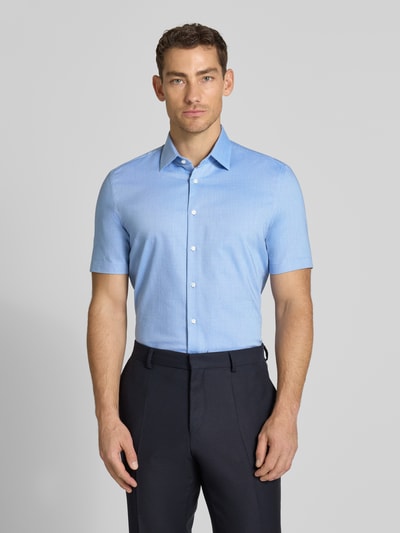 Männermodel trägt Slim Fit Business-Hemd mit Kentkragen von Jake*s aus Baumwoll-Mix in Hellblau, glatte Textur, Ganzkörperansicht von vorne.
