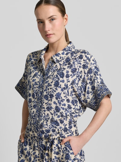 Vrouwenmodel draagt jumpsuit uit zuiver viscose met all-over look en strikceintuur, model 'Mathilde' van LOLLYS LAUNDRY, nahaufnahme bovenlichaam.