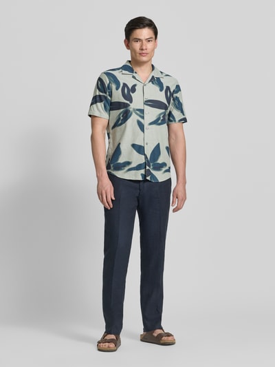 Męski model nosi Casual Fit Freizeithemd im Allover-Look od OLYMP Level Five, bawełna, krój casual fit, kołnierz rewersowy, jasnoniebieskie i granatowe liście, całkowita długość tyłu w rozmiarze M: 72 cm, szerokość w rozmiarze M: 46 cm, długość rękawa w rozmiarze M: 26 cm, pełny widok z przodu.