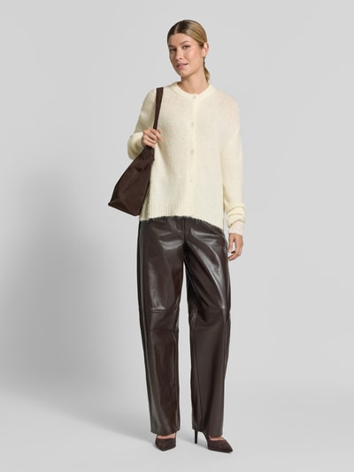 Frauenmodel trägt Cardigan mit Alpaka-Anteil und Rundhalsausschnitt Modell 'OTIA' von b.young in Creme, kombiniert zu brauner Hose, Ganzkörperansicht von vorne. Regular Fit, Knopfleiste, Material-Mix, Rückenlänge 52 cm, Ärmellänge 58 cm.