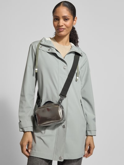 Frauenmodel trägt Handtasche mit Reißverschluss Modell 'BOX BAG MICRO' von RAINS, metallic glänzend, Label-Detail, verstellbarer Schulterriemen, Ganzkörperansicht von vorne.