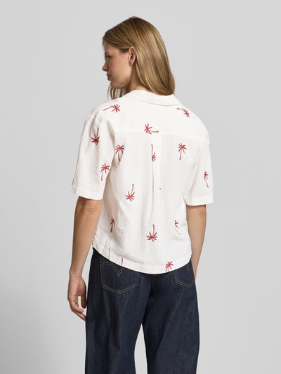 Frauenmodel trägt Loose Fit Hemdbluse aus reiner Bio-Baumwolle Modell 'KIANA' von Pieces, weiß mit roten Motiv-Stitchings, Crinkle-Textur, Reverskragen, V-Ausschnitt, kurzarm, unifarben, Ganzkörperansicht Rückansicht.