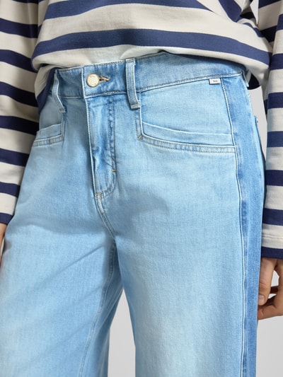Vrouwenmodel draagt Wide Fit Jeans model 'Morgan' van BRAX, lichtblauw, mix van katoen en elastaan, steekzakken, detailopname taille.
