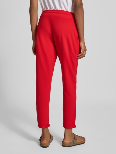 Frauenmodel trägt Slim Fit Sweatpants aus mieszanka bawełny Model 'Cozy Nights' von Mey, wpuszczane kieszenie, tunel, skrócony krój, krój slim fit, Długość wewnętrzna nogawki w rozmiarze S: 69 cm, kolor czerwony, miękka tekstura, Ganzkörperansicht Rückansicht