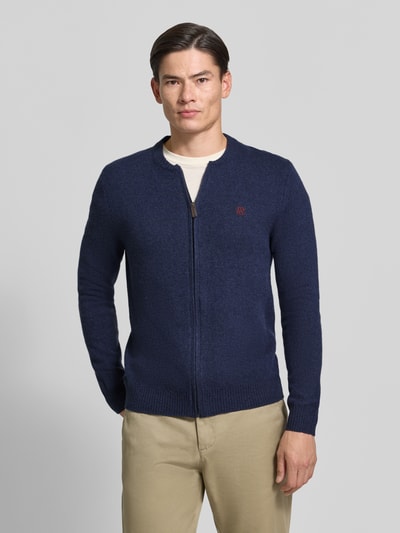 Männermodel trägt Regular Fit Strickjacke aus reiner Wolle mit Logo-Stickerei von MCNEAL, dunkelblau, gerippte Abschlüsse, Ganzkörperansicht von vorne.