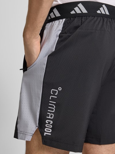 Mannenmodel draagt Shorts met Logo en elastische band van adidas Training, regular fit, bandwijdte M 38 cm, binnenbeenlengte M 19 cm, detailopname.