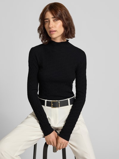 Frauenmodel trägt Slim Fit Longsleeve aus Viskose-Mix von Emporio Armani, schwarz, strukturierte Textur, Stehkragen, Nahaufnahme Oberkörper.