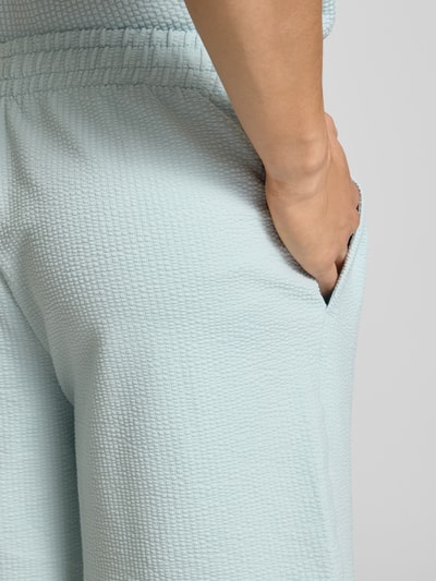 Männermodel trägt Shorts mit Logo-Stitching von PUMA PERFORMANCE in Hellblau, Strukturmuster, elastischer Bund, Detailaufnahme seitlich